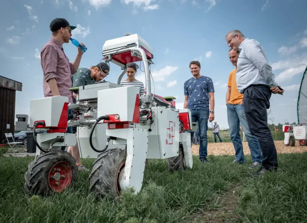 Professor Pål Johan From, i blå T-skjorte, forskere/studenter ved NMBU og ansatte i Saga Robotics med jordbærroboten Thorvald som de har utviklet