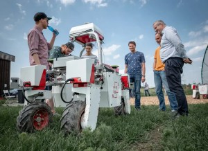 Professor Pål Johan From, i blå T-skjorte, forskere/studenter ved NMBU og ansatte i Saga Robotics med jordbærroboten Thorvald som de har utviklet